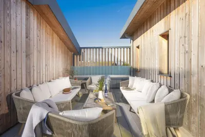 a patio with white couches and a table and chairs at Harlyn Penthouse, Harlyn Bay - 1 pet accepted - Free Wi-fi - Sea View in St Merryn
