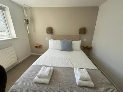 a bedroom with a bed with two towels on it at Beach house with expansive sea views! in Newquay