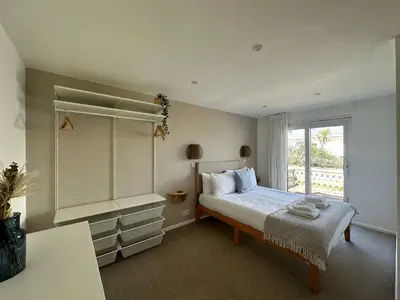 a bedroom with a large bed and a window at Beach house with expansive sea views! in Newquay