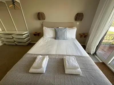 a bedroom with a bed with two white towels on it at Beach house with expansive sea views! in Newquay