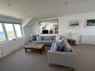 a living room with a couch and a table at Beach house with expansive sea views! in Newquay