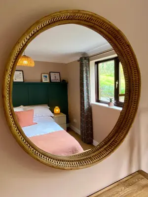 a bedroom with a bed and a mirror at About Time Meva - stylish two-bedroom, dog-friendly home-from-home with parking and garden in Mevagissey