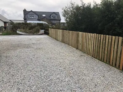 a wooden fence in front of a house at Singing Cottage in Port Isaac