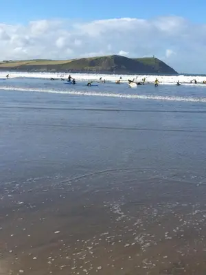 a group of people in the water at the beach at Singing Cottage in Port Isaac