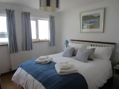 a bedroom with a bed with towels on it at Singing Cottage in Port Isaac