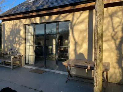 a bench sitting in front of a building with windows at Tresahor Studio with sauna in Falmouth
