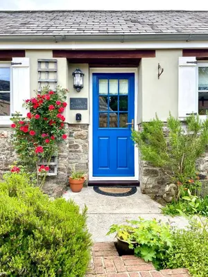 a blue front door of a house with flowers at The Cowshed - Cottage in Cornwall in Jacobstow