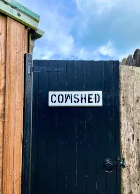 a black gate with a sign that readsconsumed at The Cowshed - Cottage in Cornwall in Jacobstow