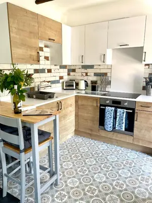 a kitchen with white cabinets and a table and a counter at The Cowshed - Cottage in Cornwall in Jacobstow