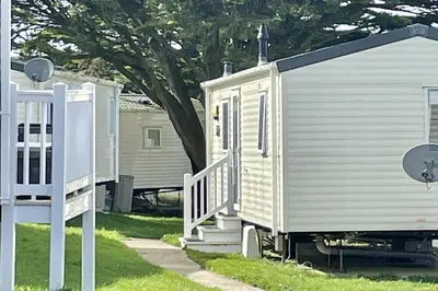a white house with a porch and a gate at 2 Bedrooms Sleeps 6 Fast WiFi Pet Friendly in Newquay