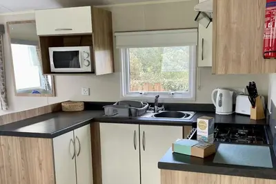 a small kitchen with a sink and a microwave at 2 Bedrooms Sleeps 6 Fast WiFi Pet Friendly in Newquay