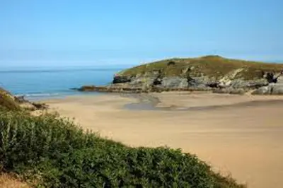 a sandy beach with an island in the ocean at 2 Bedrooms Sleeps 6 Fast WiFi Pet Friendly in Newquay