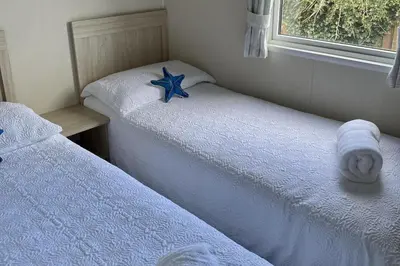 two beds in a bedroom with a starfish on them at 2 Bedrooms Sleeps 6 Fast WiFi Pet Friendly in Newquay