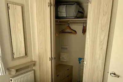 a closet with a door and a shelf and a mirror at 2 Bedrooms Sleeps 6 Fast WiFi Pet Friendly in Newquay