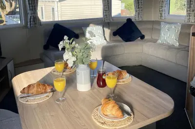 a table with three plates of croissants and glasses of orange juice at 2 Bedrooms Sleeps 6 Fast WiFi Pet Friendly in Newquay