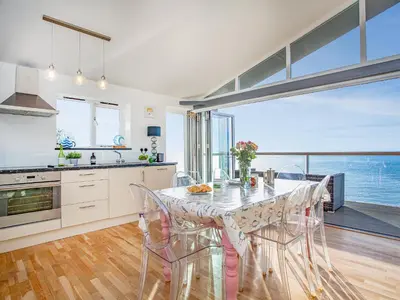 a kitchen and dining room with a table and chairs at Lookout in Downderry