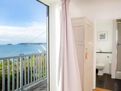 a room with a balcony with a view of the ocean at Lookout in Downderry