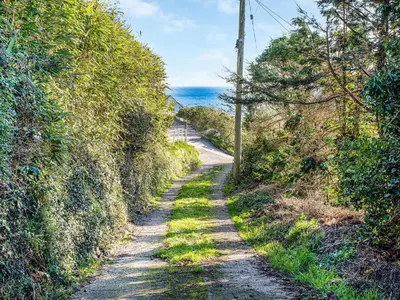 a dirt road with the ocean in the background at Lookout in Downderry