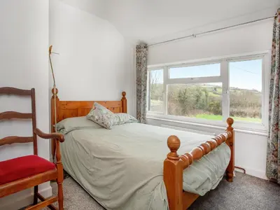 a bedroom with a bed and a chair and a window at Carneggo in Saint Dennis