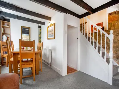 a dining room with a staircase and a table and chairs at Carneggo in Saint Dennis