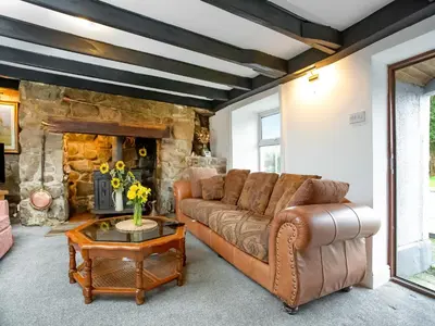 a living room with a couch and a stone fireplace at Carneggo in Saint Dennis