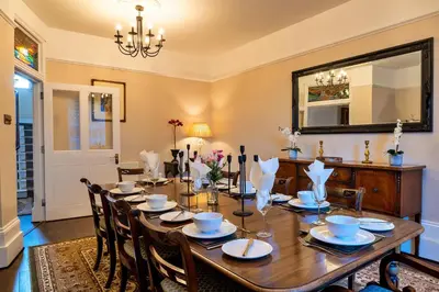 a dining room with a table with chairs and a mirror at Finest Retreats - The Old Counting House in Gweek