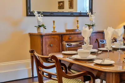 a dining room with a wooden table and a mirror at Finest Retreats - The Old Counting House in Gweek