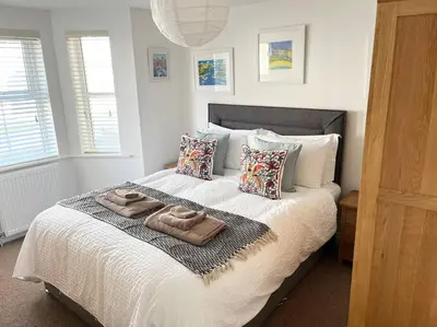a bedroom with a bed with two towels on it at Seascape Stay No 4, Sea View & Parking in Falmouth
