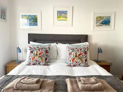 a bedroom with a large bed with pillows on it at Seascape Stay No 4, Sea View & Parking in Falmouth