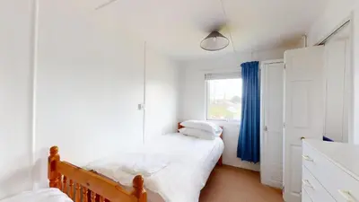 a bedroom with two beds and a window at E04 Fresno, Riviere Towans in Hayle