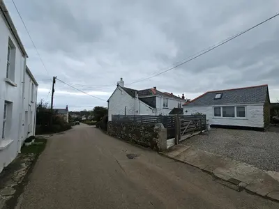 an empty street with a white house and a house at End Cottage Veryan Cornwall in Truro