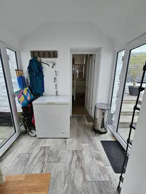 a room with a counter and a hallway with windows at End Cottage Veryan Cornwall in Truro