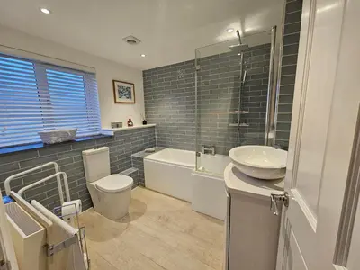 a bathroom with a sink and a toilet and a tub at End Cottage Veryan Cornwall in Truro