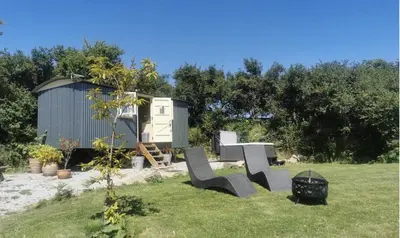 a tiny house in a yard next to a shed at The Daffodil Hut in Porkellis