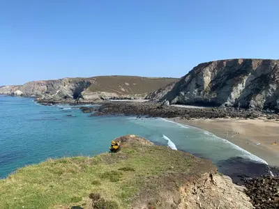 a beach with a rock in the water at Lovely flat, balcony & woodstove, parking close in St. Agnes