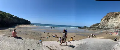 a group of people on a beach near the ocean at Lovely flat, balcony & woodstove, parking close in St. Agnes