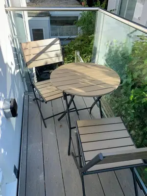 a table and two chairs sitting on a deck at Lovely flat, balcony & woodstove, parking close in St. Agnes