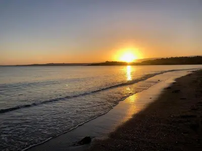 a sunset on a beach with the sun setting at Exceptional retreat near Cornwall Coast in Tywardreath