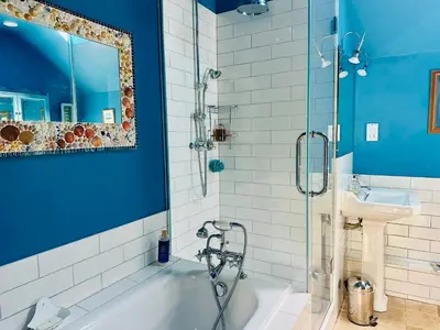 a blue bathroom with a tub and a sink at Exceptional retreat near Cornwall Coast in Tywardreath