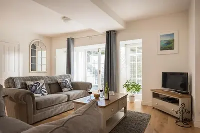 a living room with a couch and a tv at Stone's Throw - 2 Bed Apartment Centre of Falmouth in Falmouth
