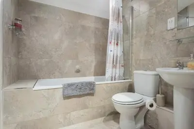a bathroom with a toilet and a tub and a sink at Stone's Throw - 2 Bed Apartment Centre of Falmouth in Falmouth