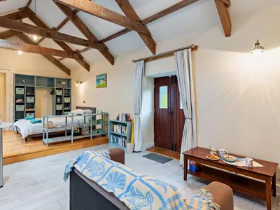 a living room with a couch and a table at Tiptoe Barn in Liskeard