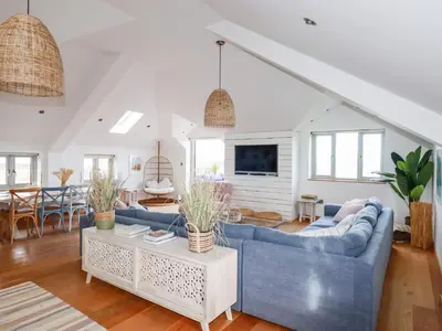 a living room with a blue couch and a table at Sea View House in Newquay