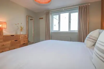 a bedroom with a large white bed and a window at Sea View House in Newquay