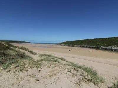 a beach with people walking on the sand at Sea View House in Newquay