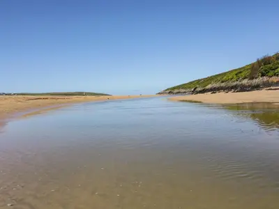 a body of water next to a sandy beach at Sea View House in Newquay