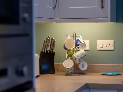 a kitchen counter with cups and utensils on it at Holiday Home Valley View by Interhome in Mevagissey