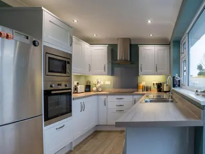 a kitchen with white cabinets and a counter top at Holiday Home Valley View by Interhome in Mevagissey