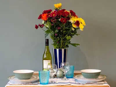 a bottle of wine and a vase of flowers on a table at Holiday Home Valley View by Interhome in Mevagissey