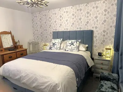 a bedroom with a large bed with a blue headboard at 3 Bed in Newquay oc-47630 in Newquay